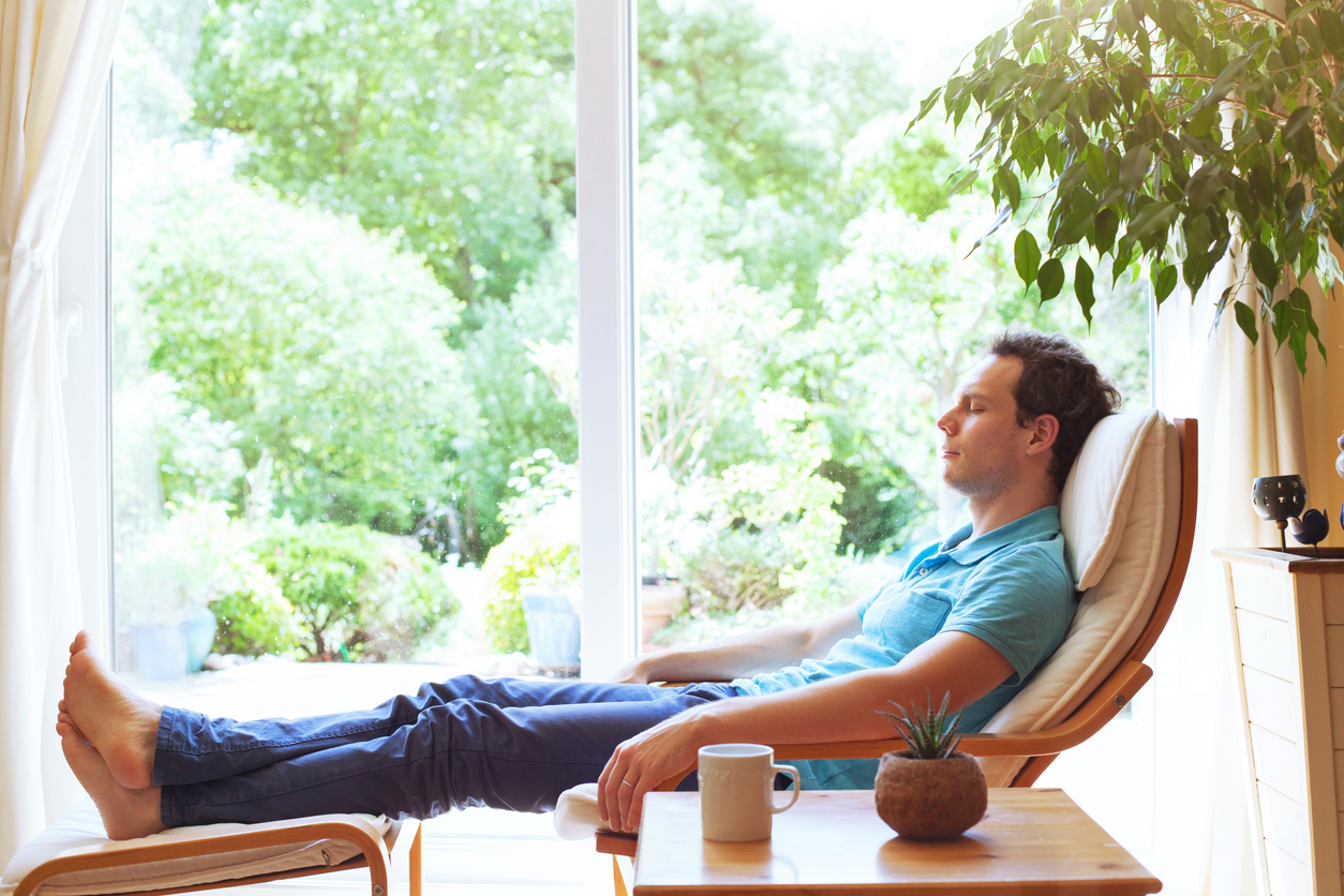 Man relaxing in a chair with his feet on a foot stool.