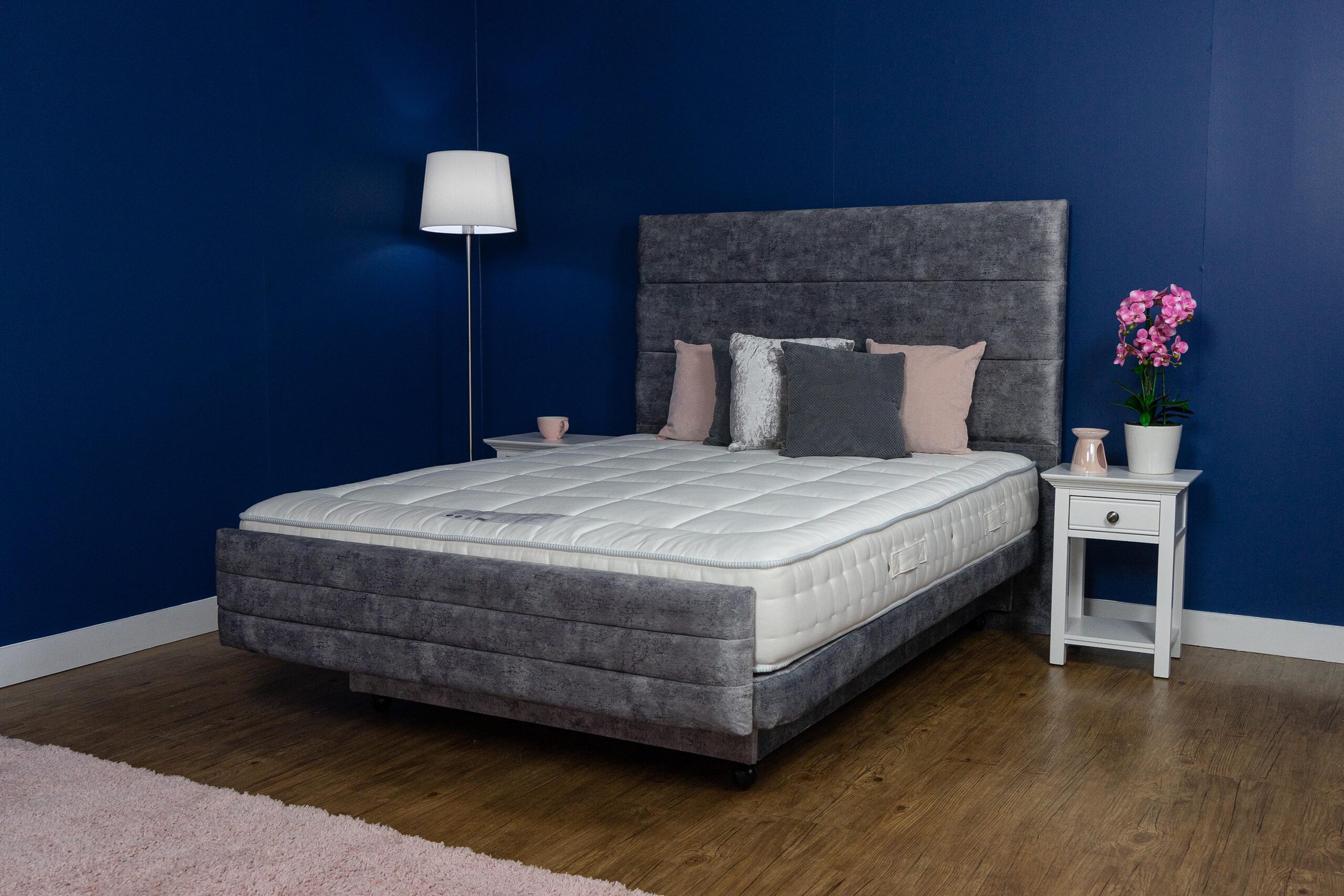 Hampton double adjustable bed. The bed has pink and grey cushions on it.