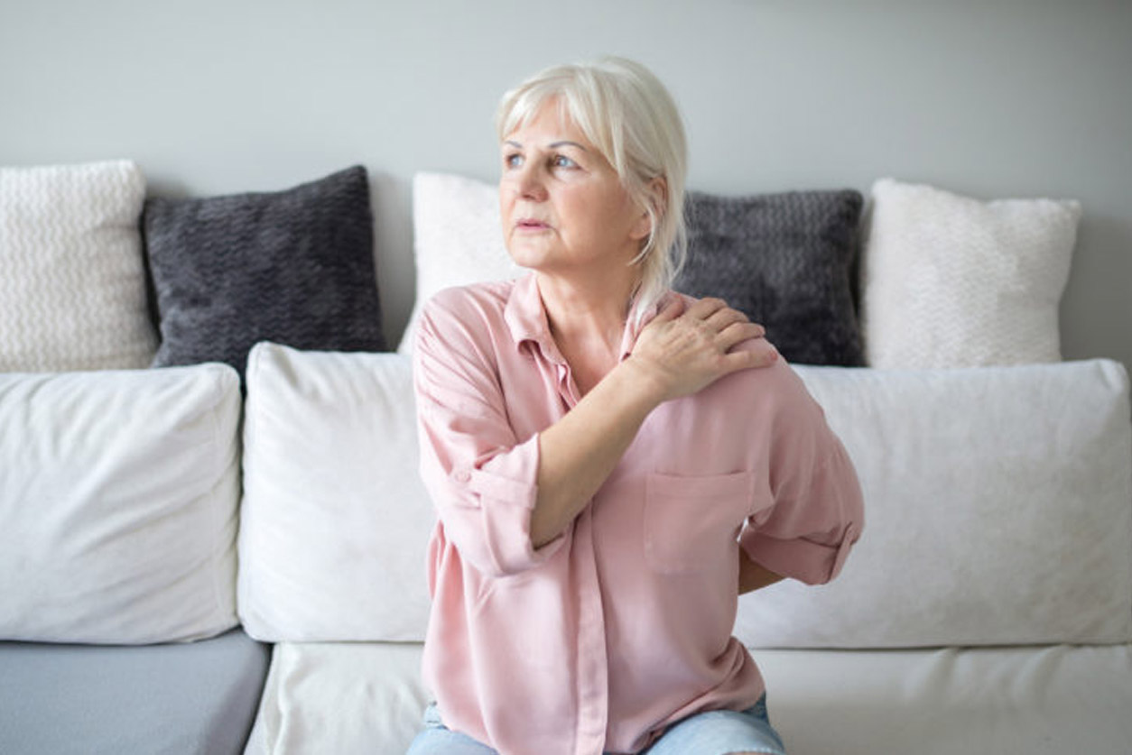 Woman stretching neck and shoulder, which can be chair based exercises